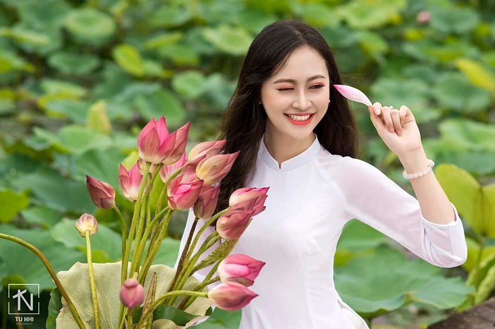 Ngắm nhìn bộ ảnh cô gái bên hồ sen đầy quyến rũ năm 2026 12 Cô gái mặc áo dài hoa sen đứng giữa hồ sen hồng