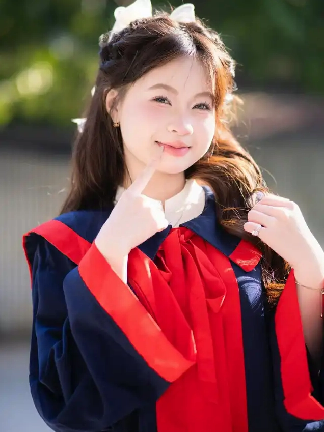 Cô gái trẻ trong trang phục cử nhân mỉm cười nhẹ nhàng