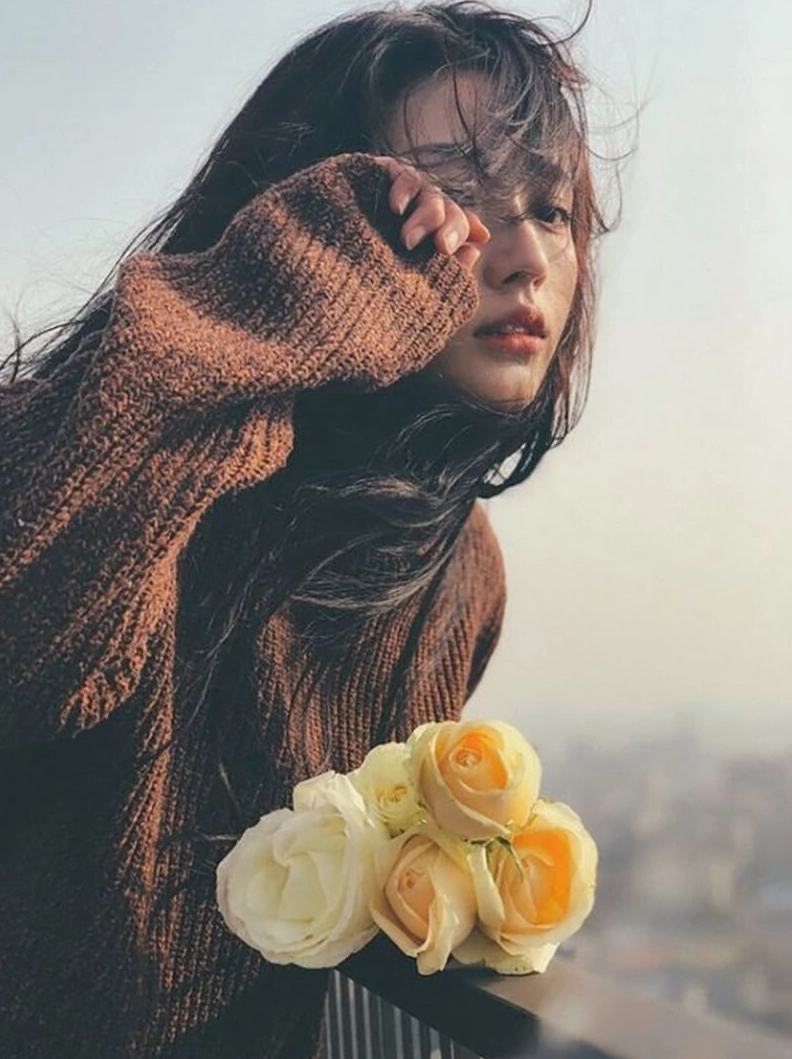 Girl cầm hoa hồng buồn đẹp trong ánh sáng dịu