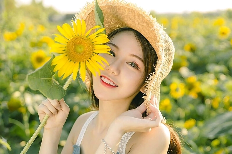 Girl xinh cầm hoa hướng dương nổi bật giữa nắng mai