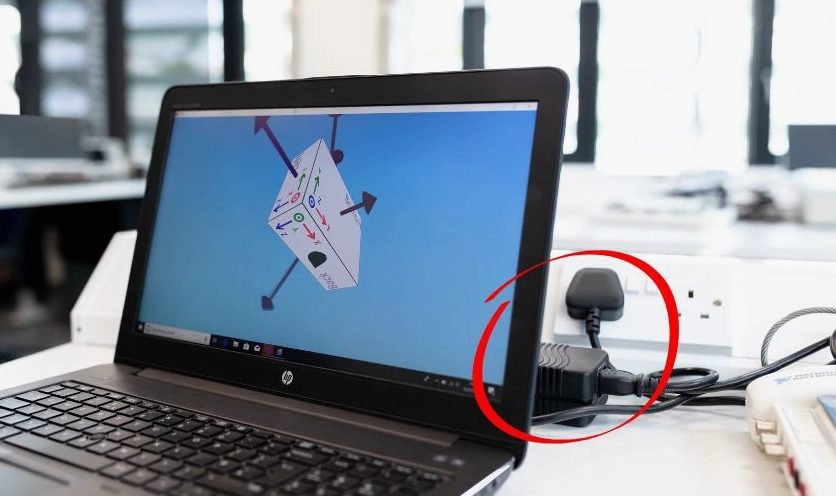 Hình ảnh một người đang làm việc cường độ cao trên laptop có cắm sạc liên tục
