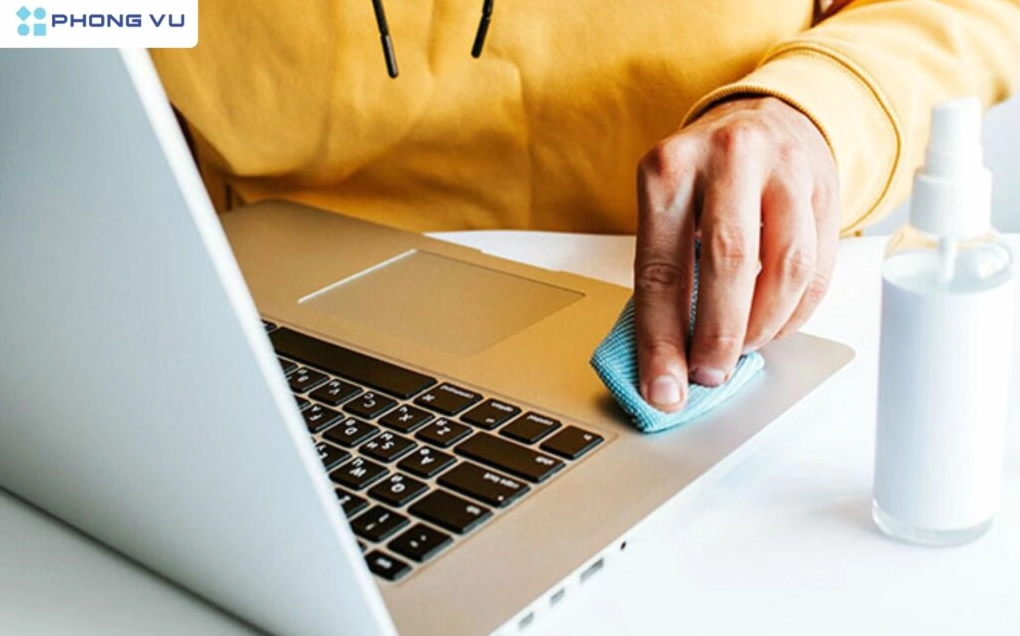 Hướng dẫn chi tiết cách sửa loa laptop bị rè hiệu quả triệt để nhất 2026 3 Hình ảnh người dùng sử dụng cọ mềm để vệ sinh khu vực khe loa trên laptop