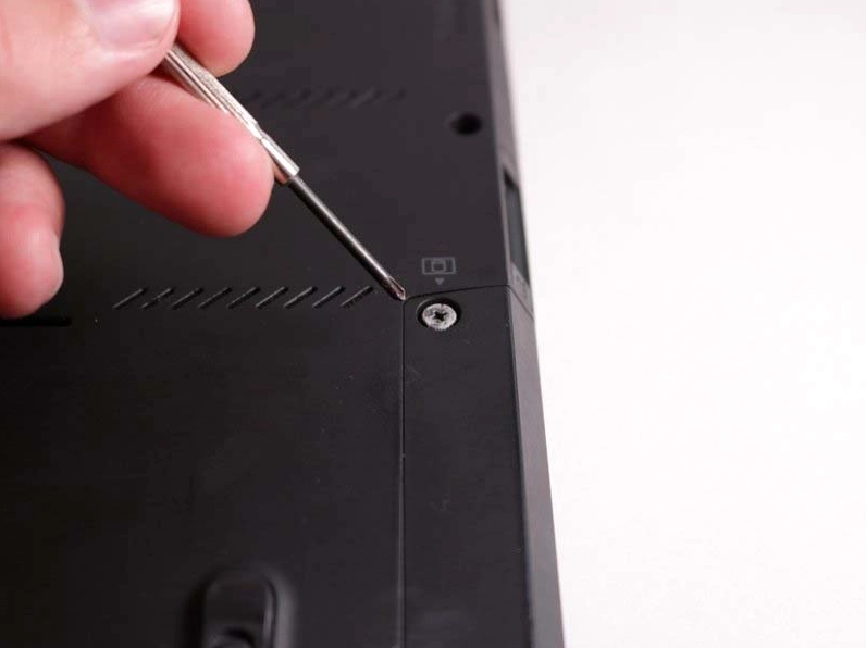 Kỹ thuật viên đang cẩn thận tháo viên pin ra khỏi laptop Lenovo để đảm bảo an toàn điện