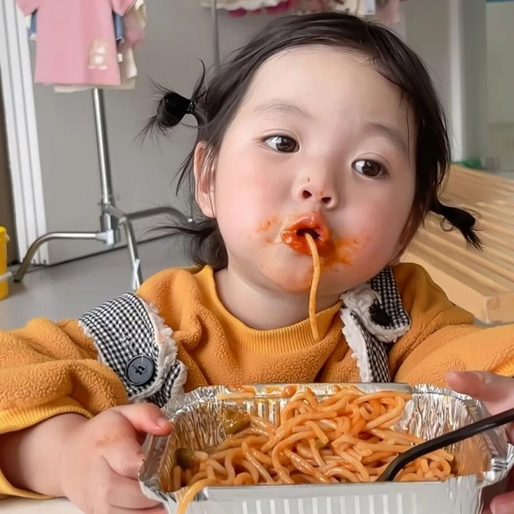 Meme em bé đang ăn với khuôn mặt dính đầy thức ăn