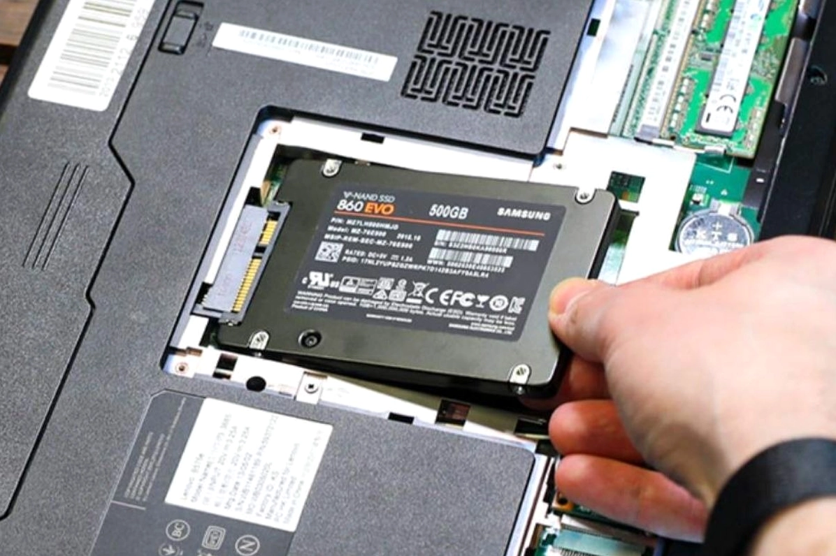 Một chiếc ổ cứng thể rắn SSD đang được đặt cạnh một chiếc máy tính xách tay