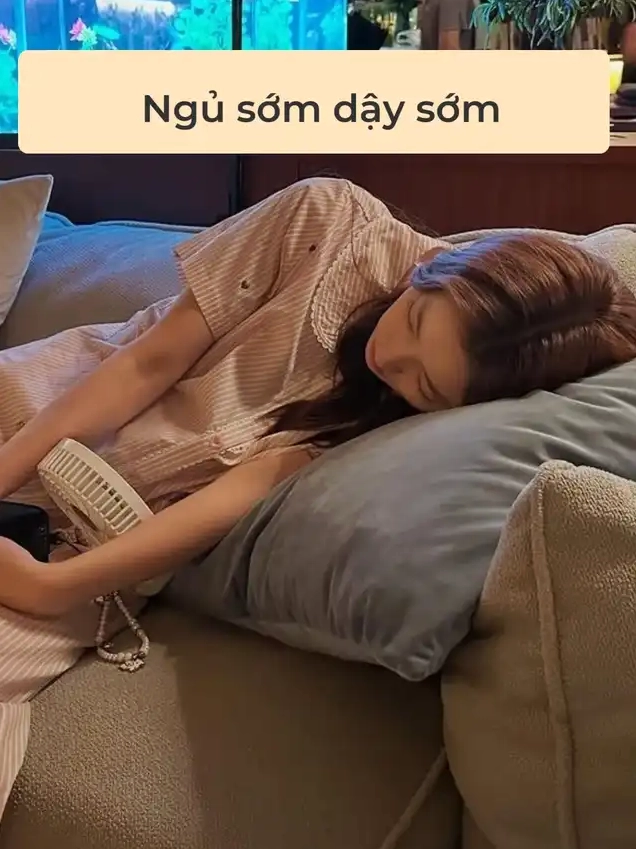Bộ sưu tập 30+ ảnh các em gái xinh tươi quyến rũ hút hồn 13 Một cô gái mặc đồ ngủ sọc đang nằm ngủ trên ghế sofa màu xám bên cạnh có chiếc quạt nhỏ minh họa cho thói quen Ngủ sớm dậy sớm
