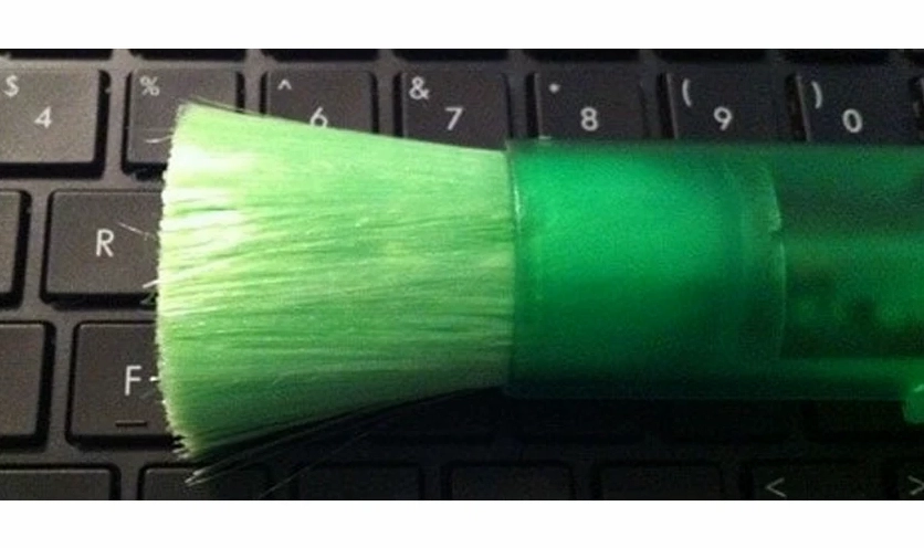 Sử dụng cây cọ mềm để quét sạch bụi bẩn bên dưới các nút phím laptop Dell