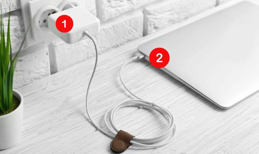 Thao tác cắm phích cắm của bộ sạc vào ổ điện tường trước khi kết nối với máy tính