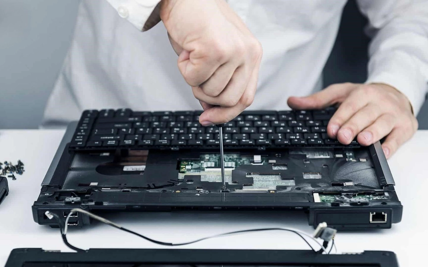 Thao tác cẩn thận tháo rời bàn phím cũ ra khỏi phần khung viền của laptop
