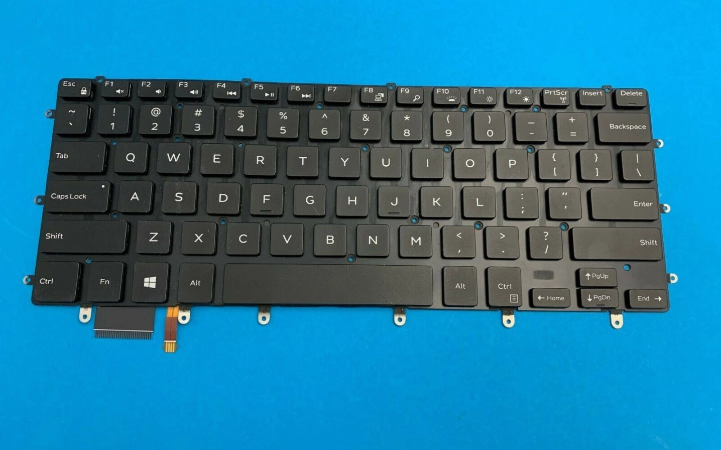 Thao tác lật nhẹ lẫy khóa để rút sợi cáp kết nối bàn phím laptop với bo mạch chủ