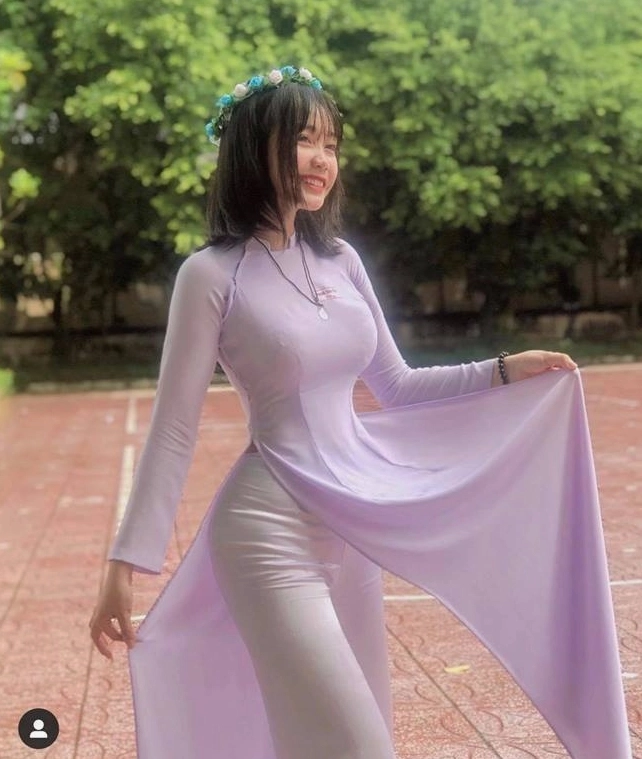 Thiếu nữ mặc áo dài trắng thướt tha dùng nón lá che mặt mang đậm nét thanh lịch truyền thống