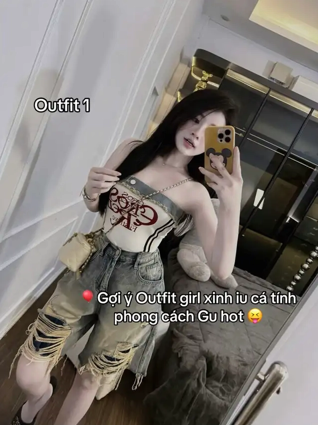 Thiếu nữ mặc áo quây và quần short jean chụp ảnh selfie trước gương