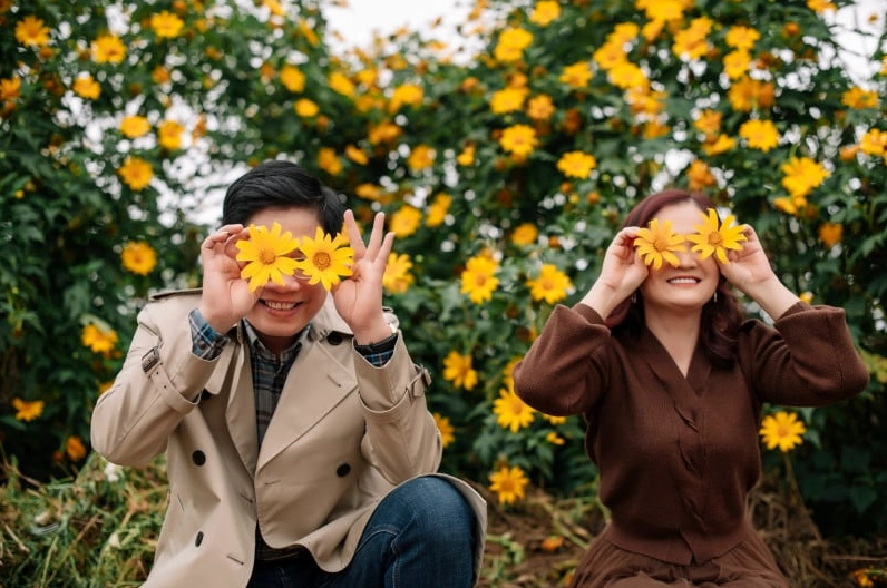 Ảnh cô gái cầm hoa đẹp bên cửa sổ tràn ngập ánh sáng