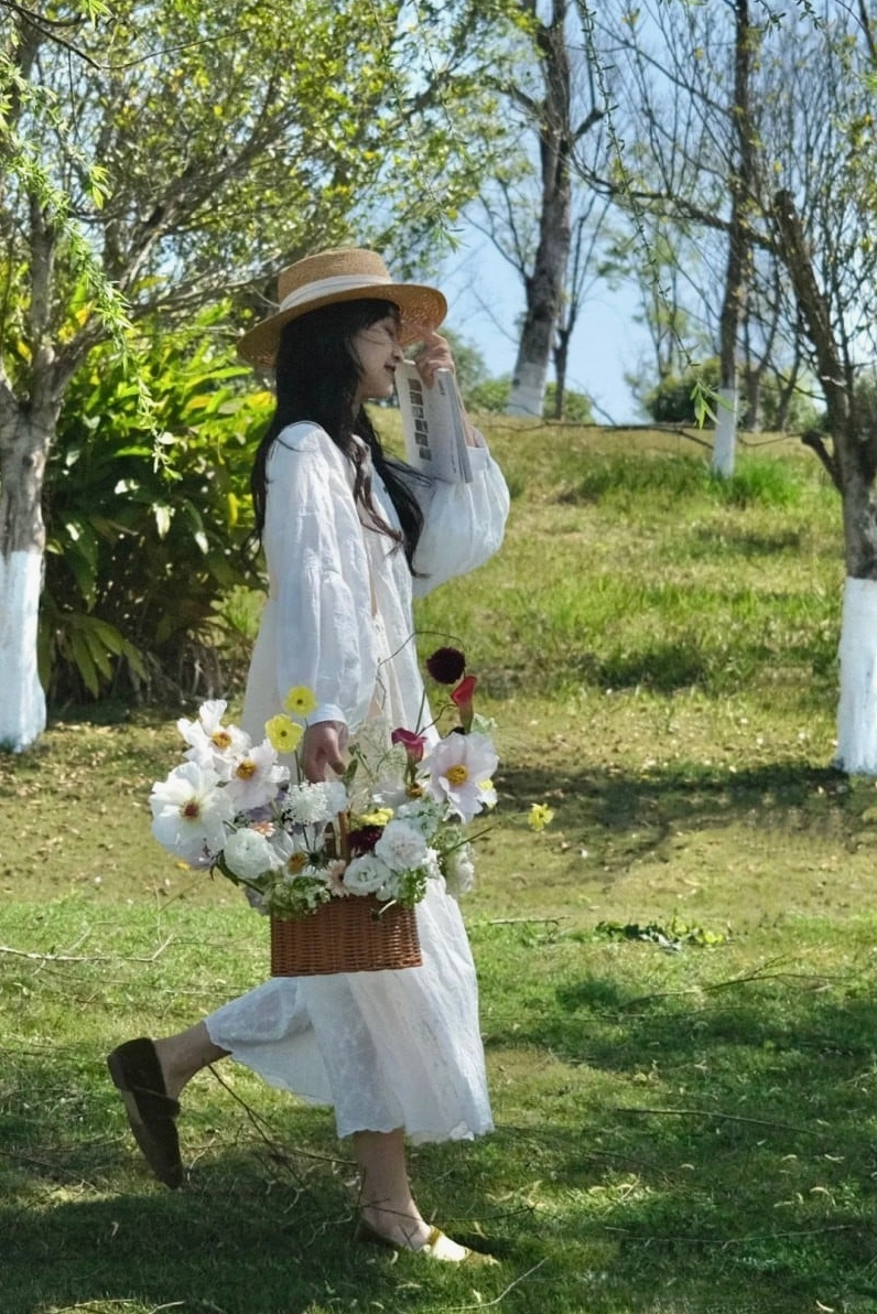 Ảnh cô gái cầm hoa đẹp với nụ cười dịu dàng