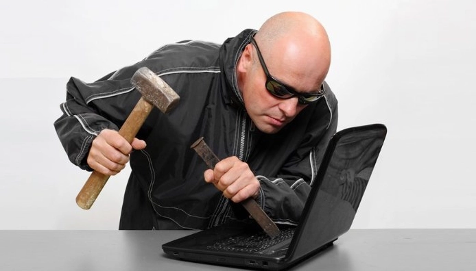 Meme hacker dùng búa gõ vào máy tính, thể hiện sự 'hack' thô bạo