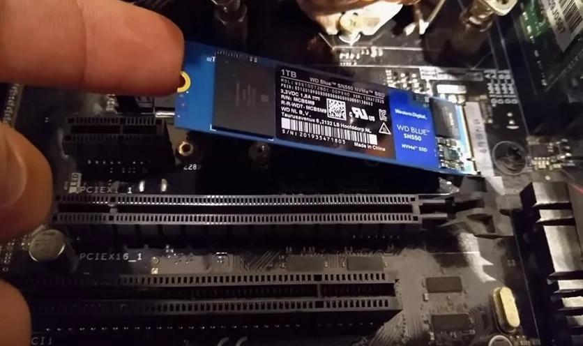 Đưa ổ cứng SSD mới vào khung kim loại và kết nối với bo mạch chủ