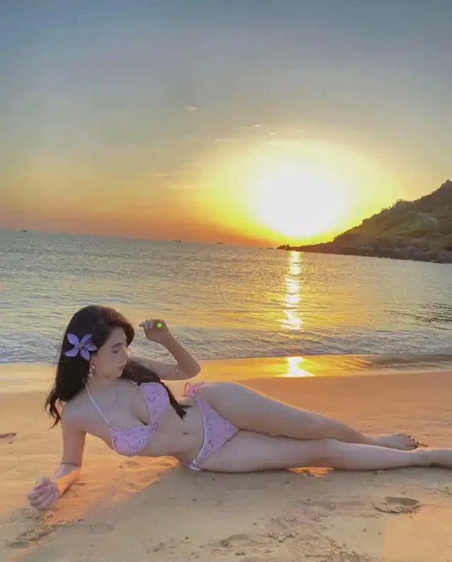 Bộ sưu tập ảnh gái xinh dáng đẹp mặc bikini quyến rũ mê hồn 4 Một cô gái mặc bikini màu hồng nằm nghiêng trên bãi cát nhìn về phía mặt trời lặn