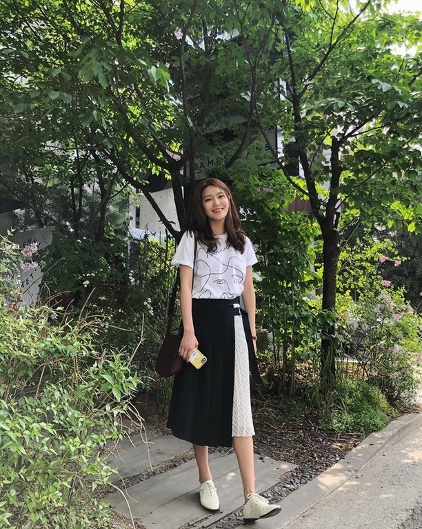 Người mẫu phong cách với áo thun rộng và chân váy đầy nữ tính